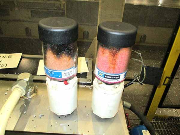 Desiccant breathers saturated with moisture. One of the breathers is even cracked needing immediate replacement. The blackish brown top layer on the desiccant beads is typically due to accumulated airborne dust, dirt, oil mist, vapors, or other fine contaminants.