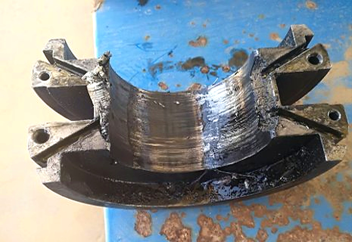 Severe scoring and metal smearing on journal bearing surface caused by metal-to-metal contact during bearing seizure on a 720 kW pump motor