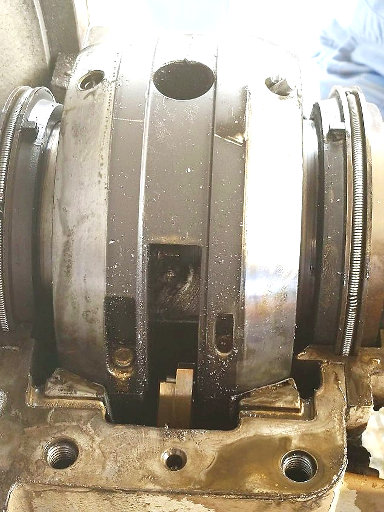Heavy sludge deposits being removed from the lubricant sump, showing contaminated and degraded oil accumulation inside the bearing housing